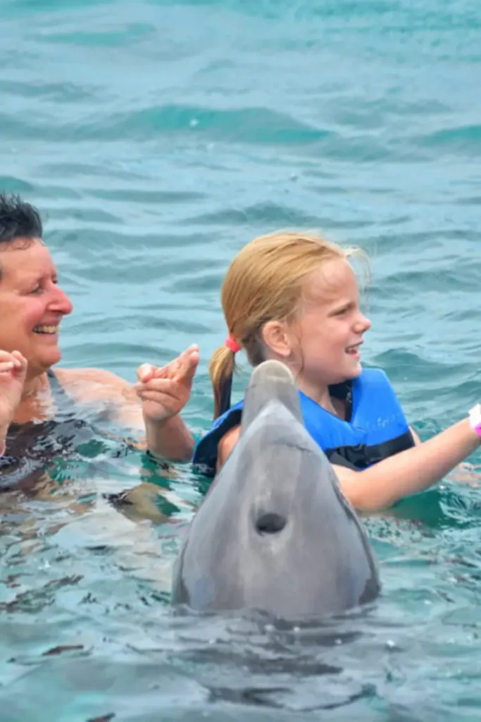 mother and daughter swimming with dolphins